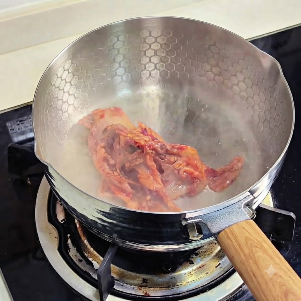 Kimchi-Stücke brutzeln in einer Pfanne.