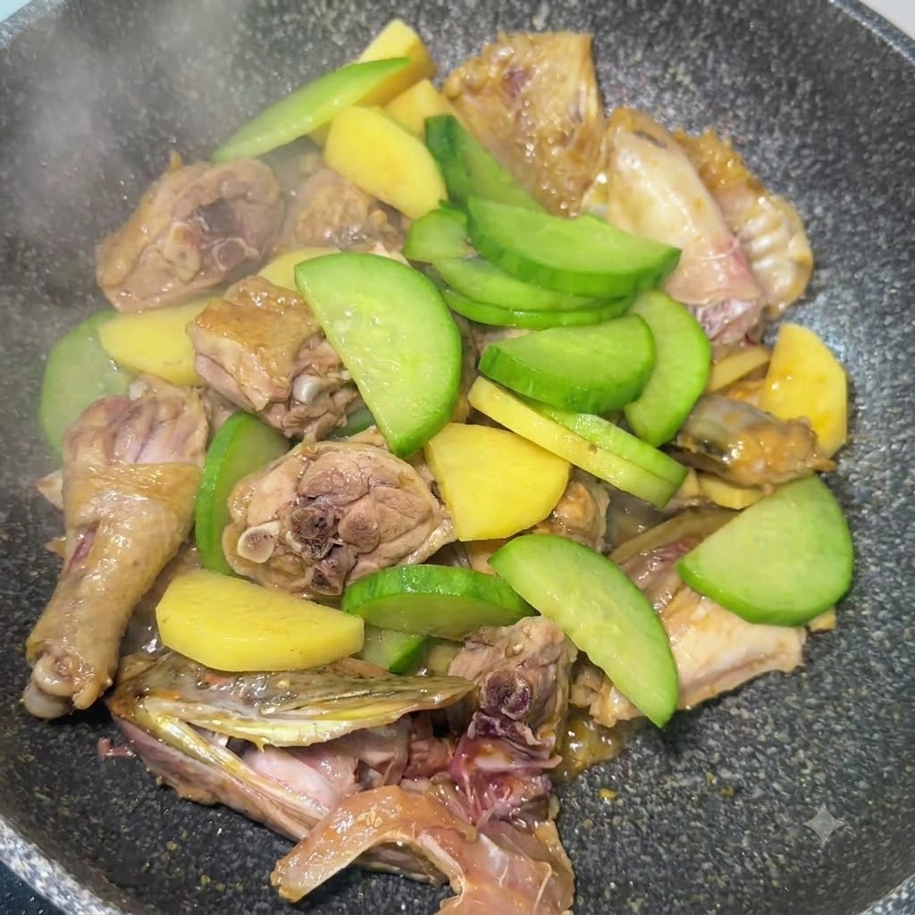 In Scheiben geschnittener grüner Rettich, vermischt mit Kartoffeln und Fischstücken, wird in der Pfanne angebraten.