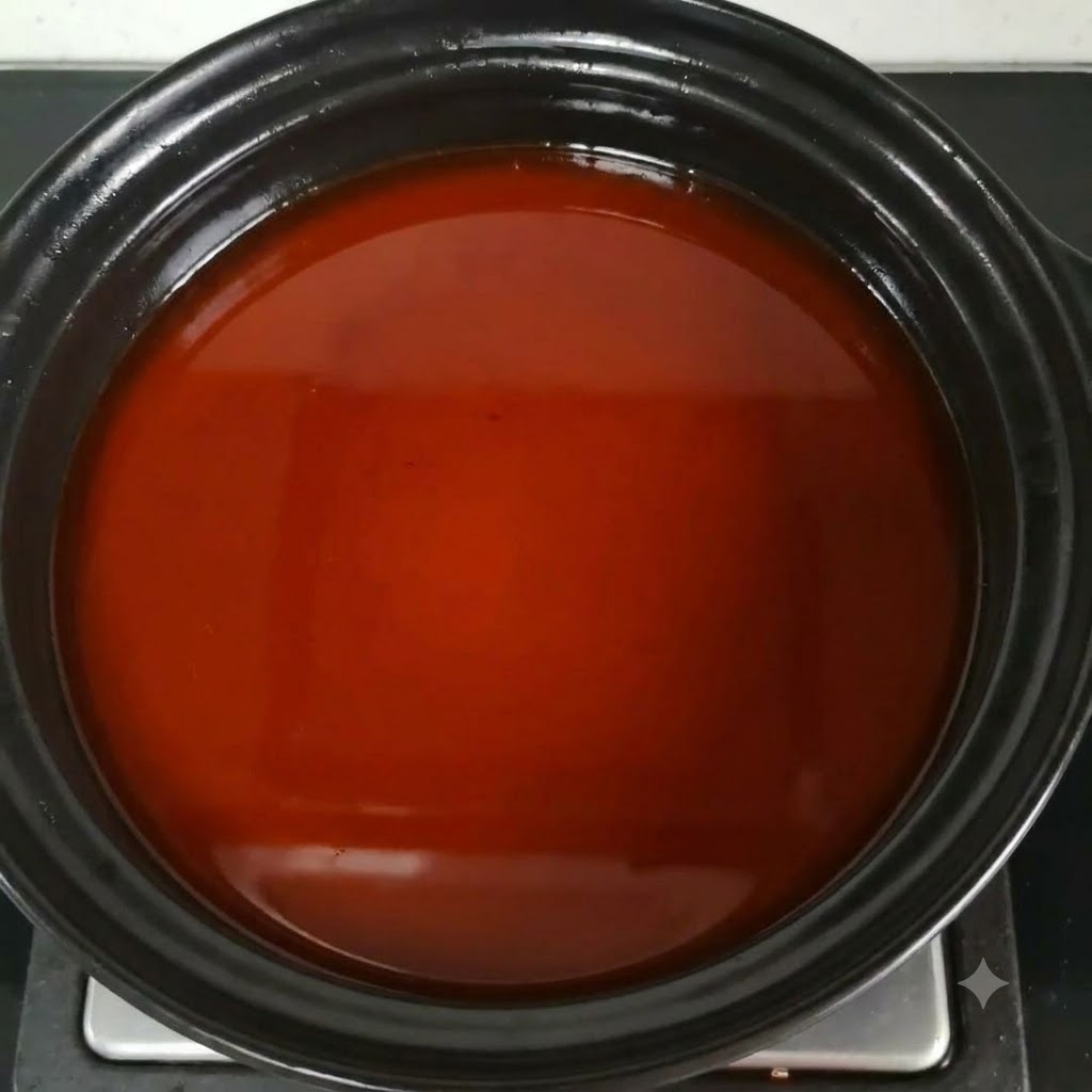 Fischsauce wird in die rötlich-braune Brühe eingerührt.