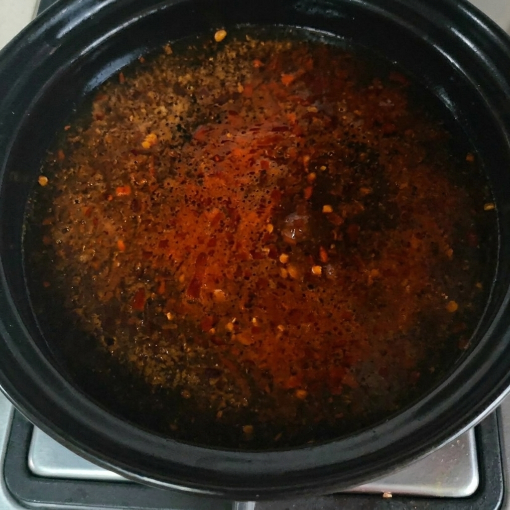Rinderbrühe-Pulver wird über die blubbernde Oberfläche der Suppe gestreut.