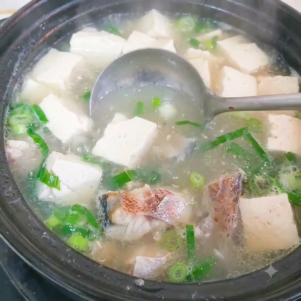 Fischstücke werden in einem Topf mit heißem Wasser blanchiert.