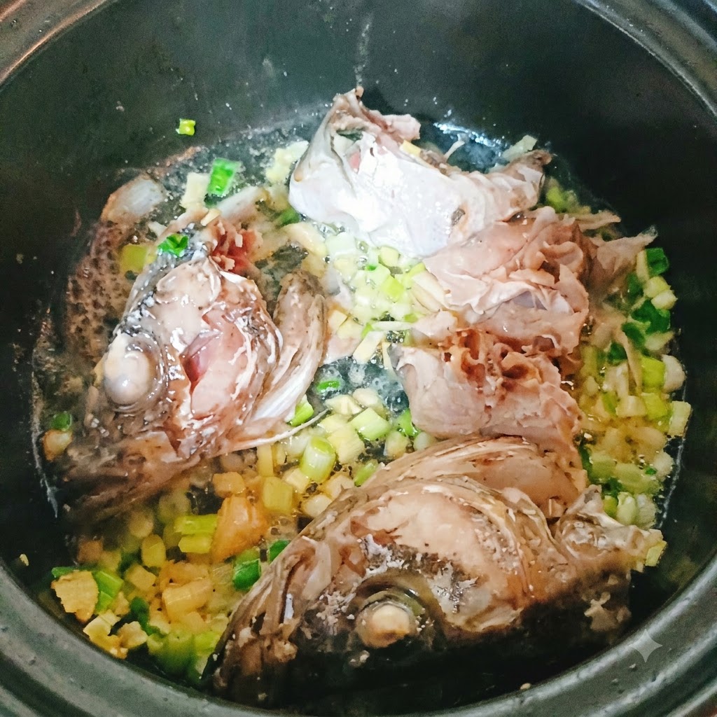 Pollock-Stücke und Kopf braten in einem Topf mit gehackten Aromaten an.