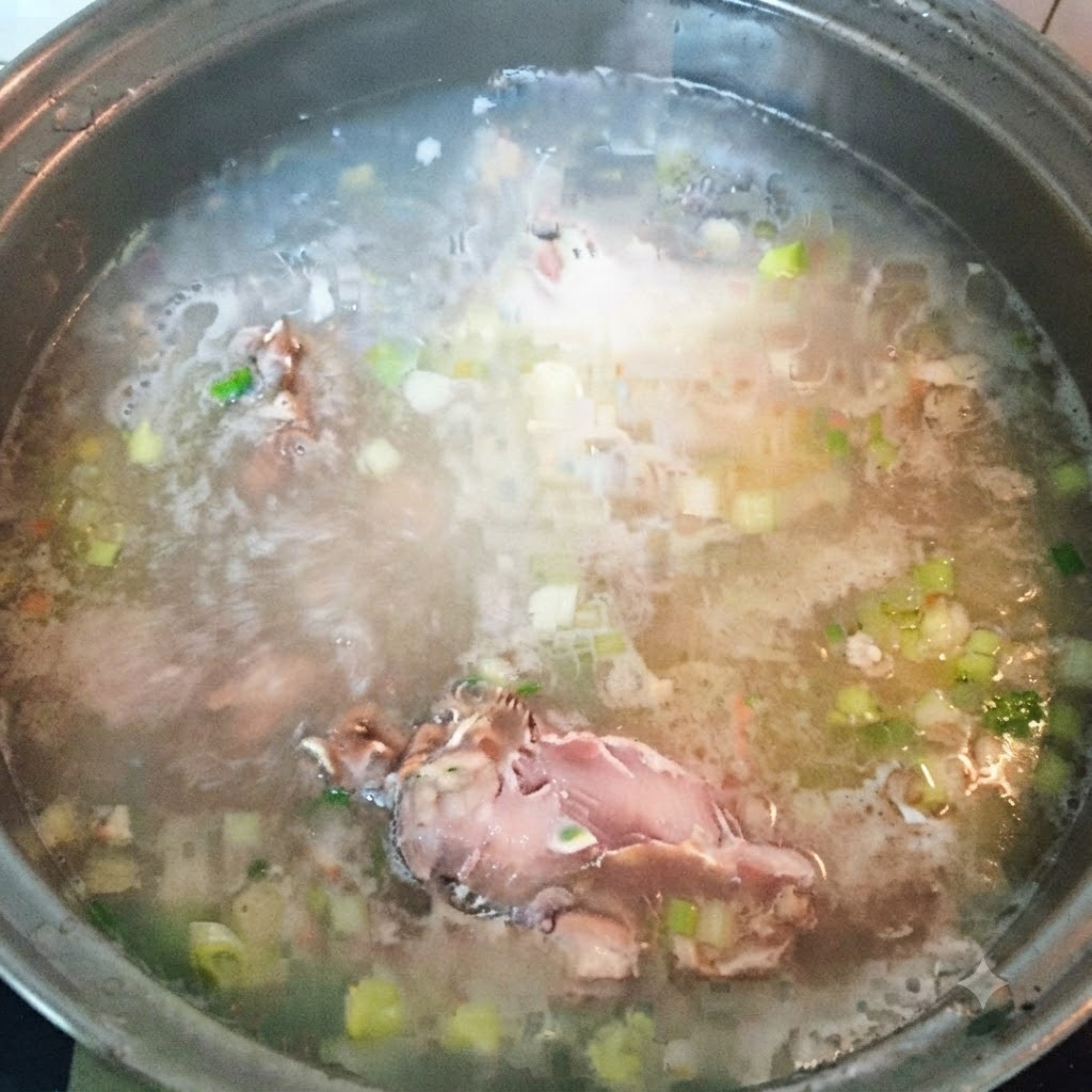 Weitere Fischstücke werden in die kochende Suppenbrühe gegeben.