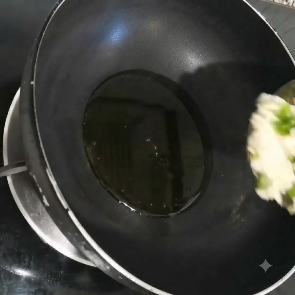 Fein gehackte Frühlingszwiebeln, Knoblauch und Koriander brutzeln in heißem Öl in einem schwarzen Wok.