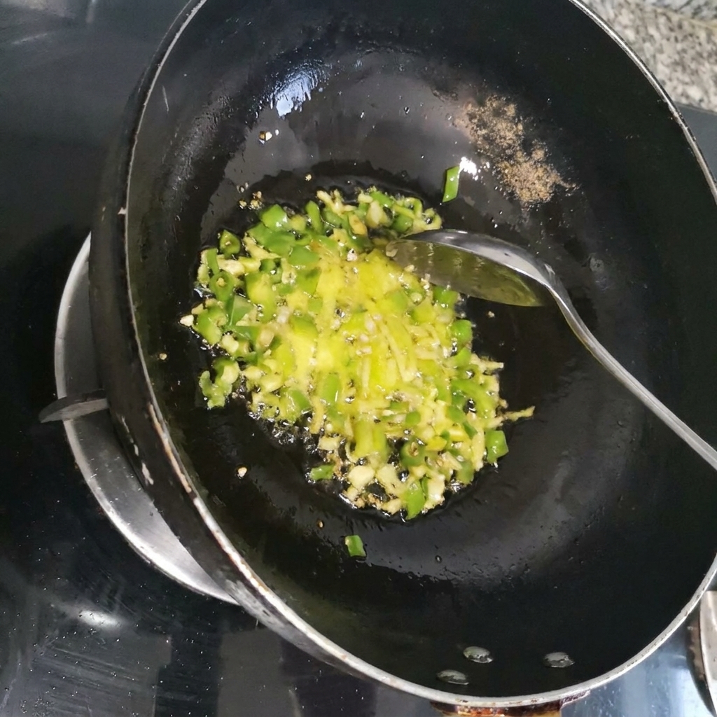 Zerkleinerte rote Chili wird mit grünen Kräutern in einem dunklen Wok pfannengerührt.