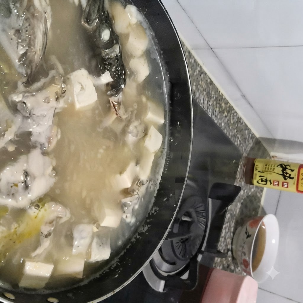 Ein Löffel schöpft Schaum von der Oberfläche eines kochenden Topfes mit Seelachs-Tofu-Suppe ab.