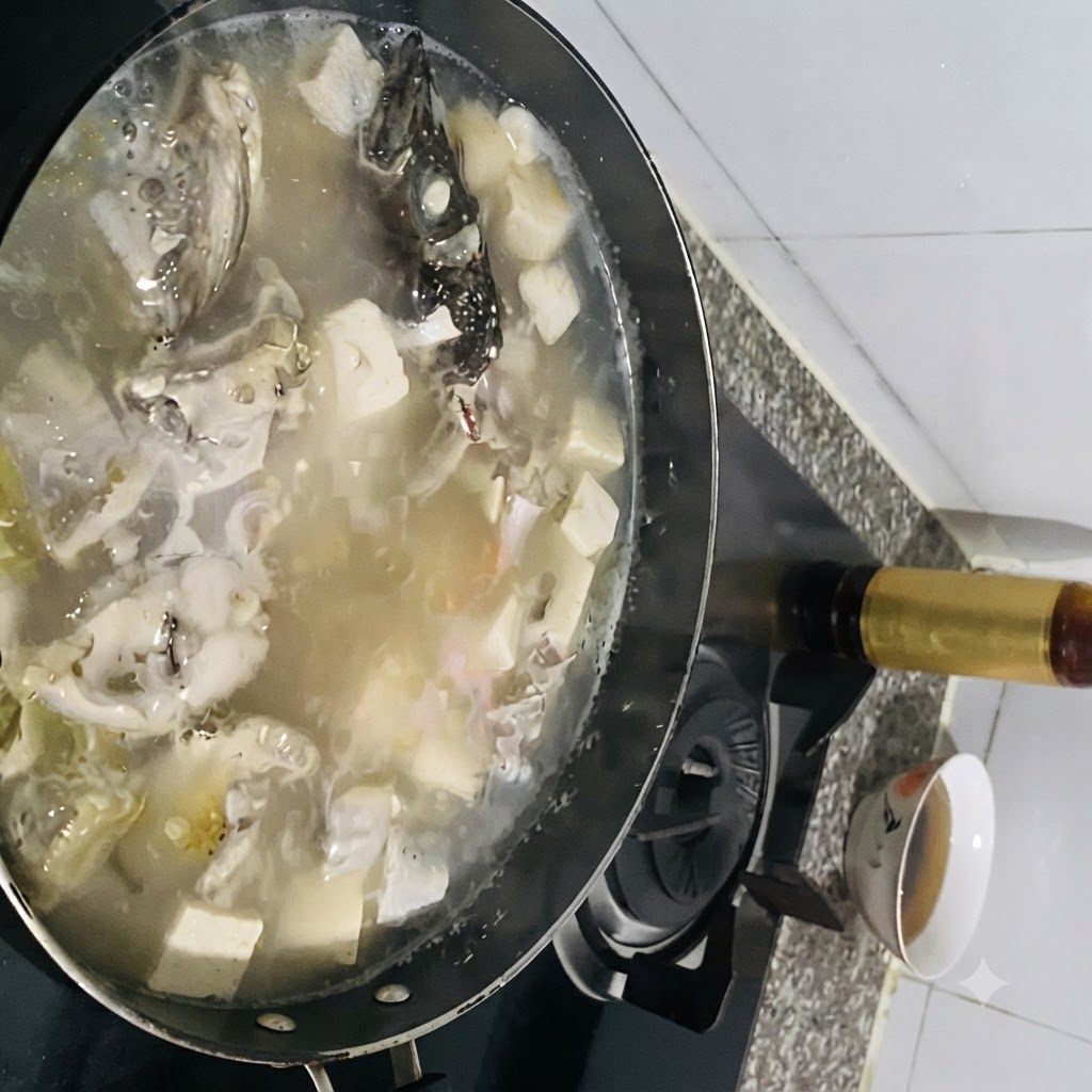 Gewürze werden in einen kochenden Topf mit Fischsuppe und Tofu gegeben.