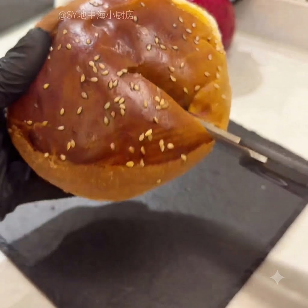 Ein aufgeschnittenes Hamburgerbrötchen mit einer Küchenschere, wobei das weiche innere Brot herausgehoben wird.