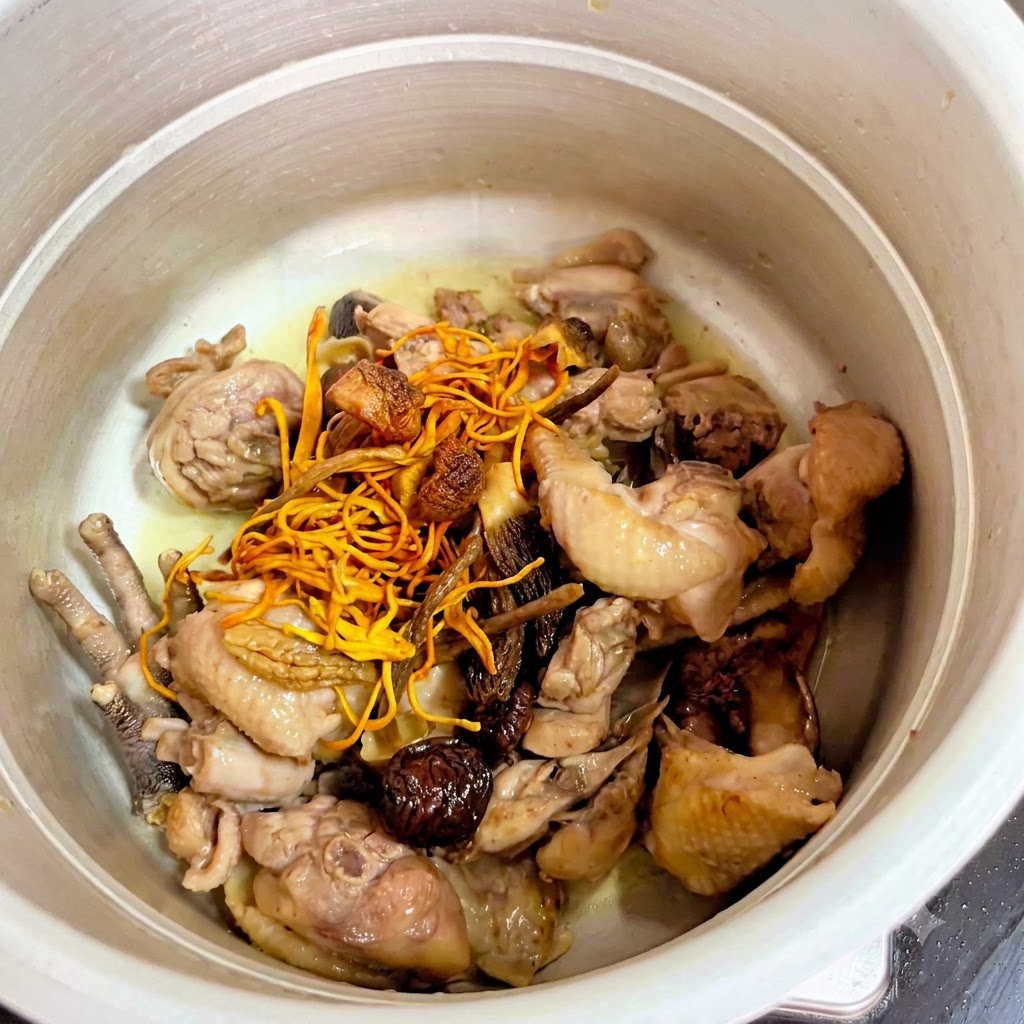 Getrocknete Pilze und gelbe Cordyceps-Blüten auf dem Hähnchen im Schnellkochtopf.