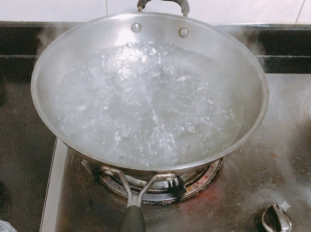 Lange Nudeln kochen in einem Topf mit kochendem Salzwasser.