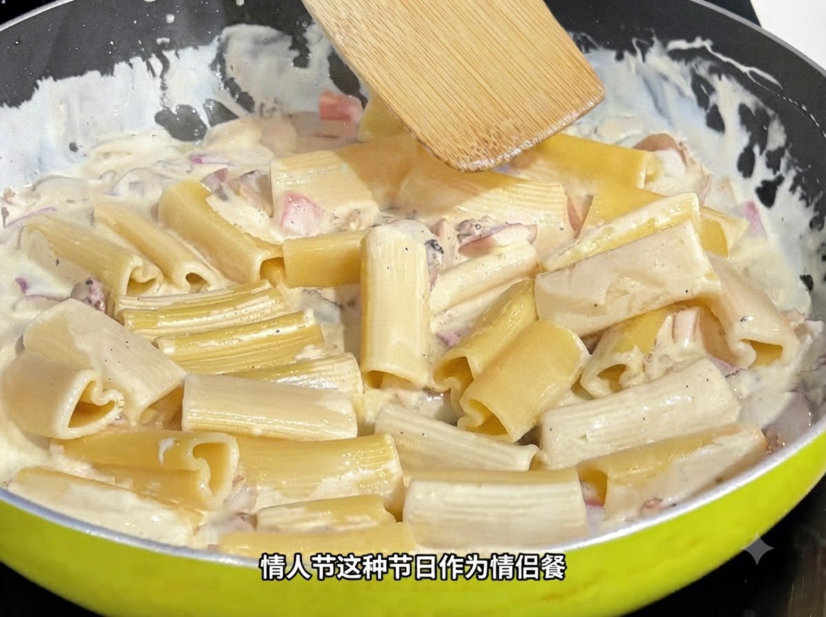 Ein Holzspatel rührt herzförmige Pasta in einer cremigen Sauce in einer Pfanne um.