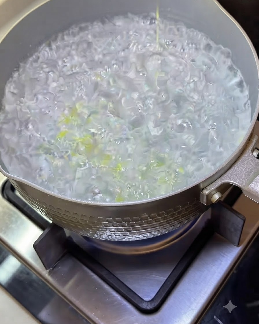 Spaghettinudeln kochen in einem Topf mit kochendem Wasser und blubbernder Flüssigkeit.