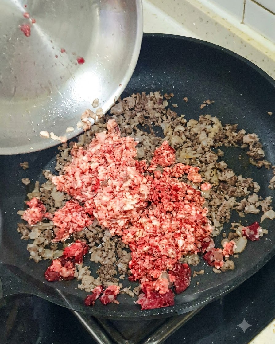 Gehackte rote Zwiebel wird in eine Pfanne mit angebratenem Hackfleisch gegeben.