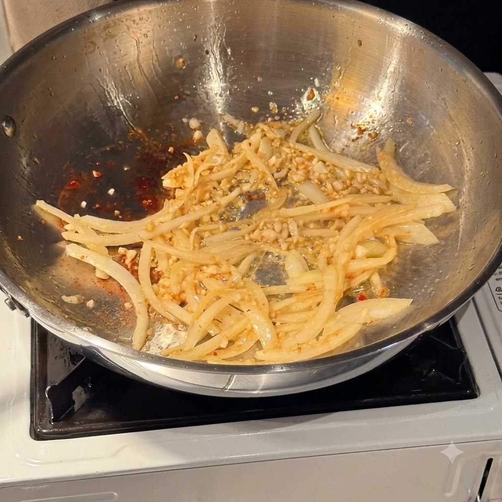 Weißwein wird in eine Pfanne mit angebratenen Zwiebeln und Knoblauch gegossen.