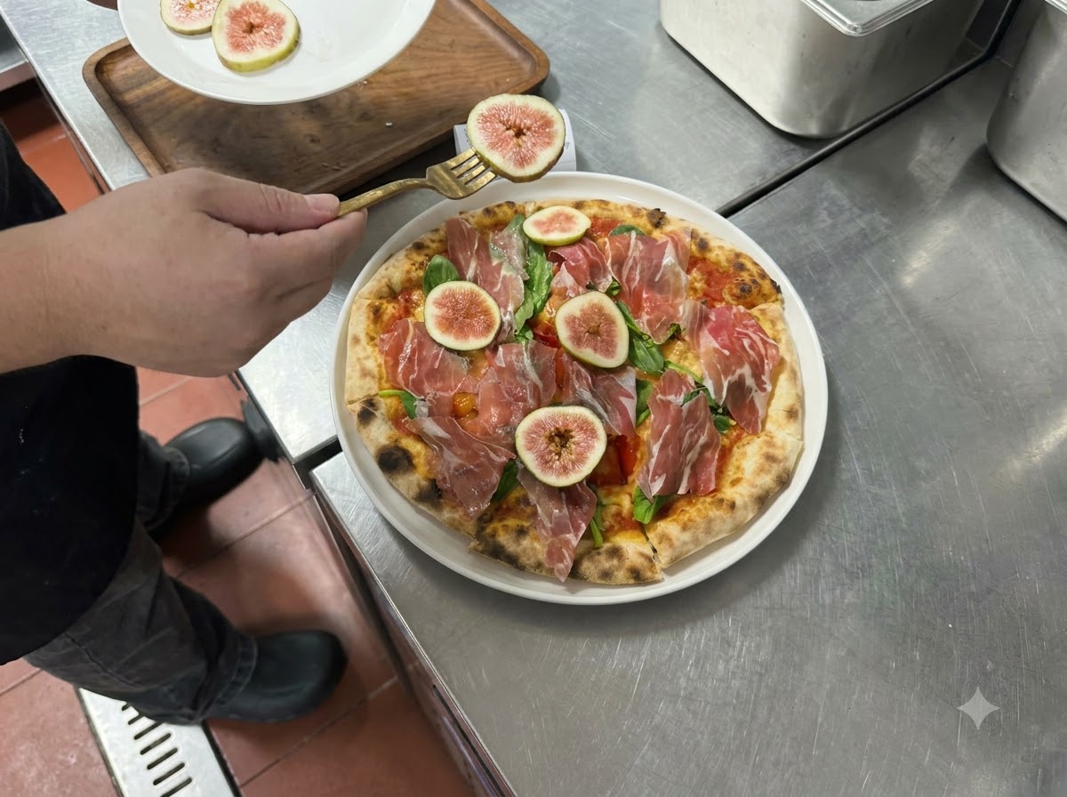 Scheiben frischer Feigen und Prosciutto werden mit einer Gabel auf einer gekochten Pizza angerichtet.
