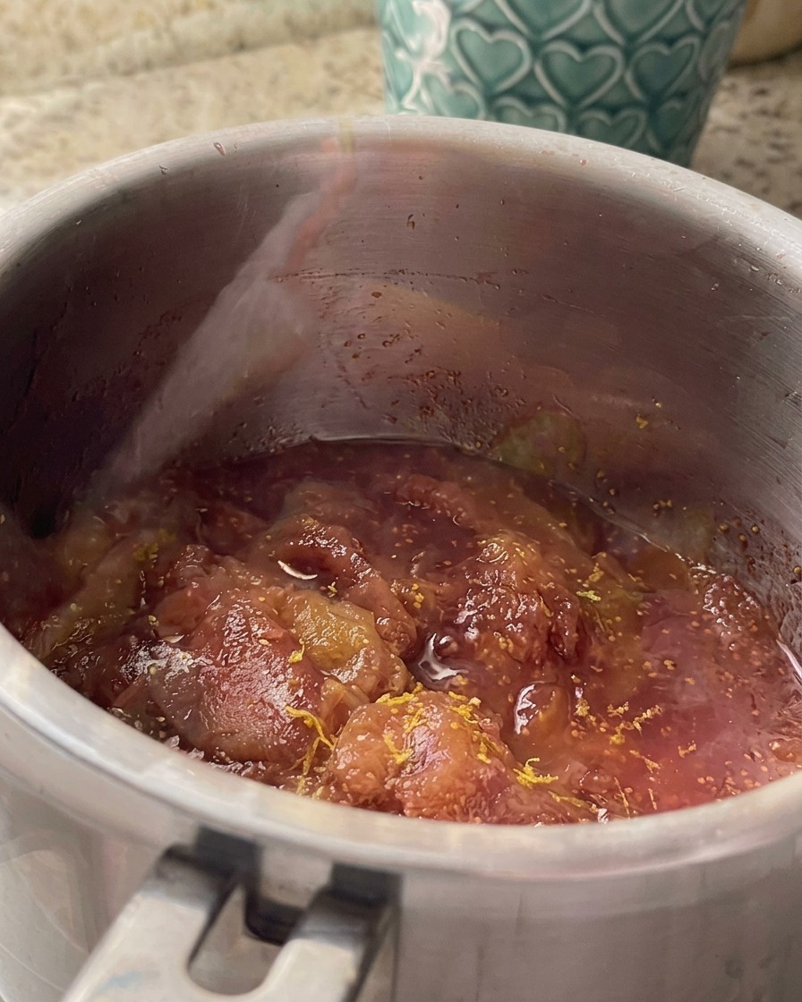 Zitronenschale und -saft werden in einem Edelstahltopf unter die köchelnde Feigensauce gerührt.