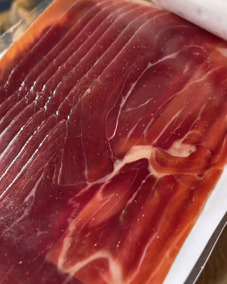 Nahaufnahme von fein geschnittenem Prosciutto, bereit zum Belegen der Feigen.