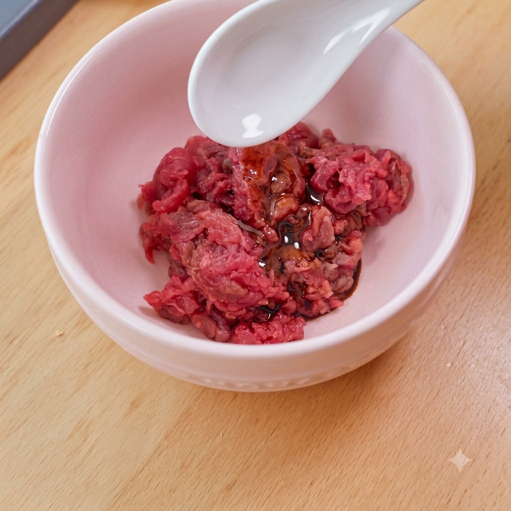 Ein weißer Löffel gibt Stärke in eine rosa Schüssel, die mit gewürfeltem rohen Rindfleisch, Sojasauce und Öl gefüllt ist.
