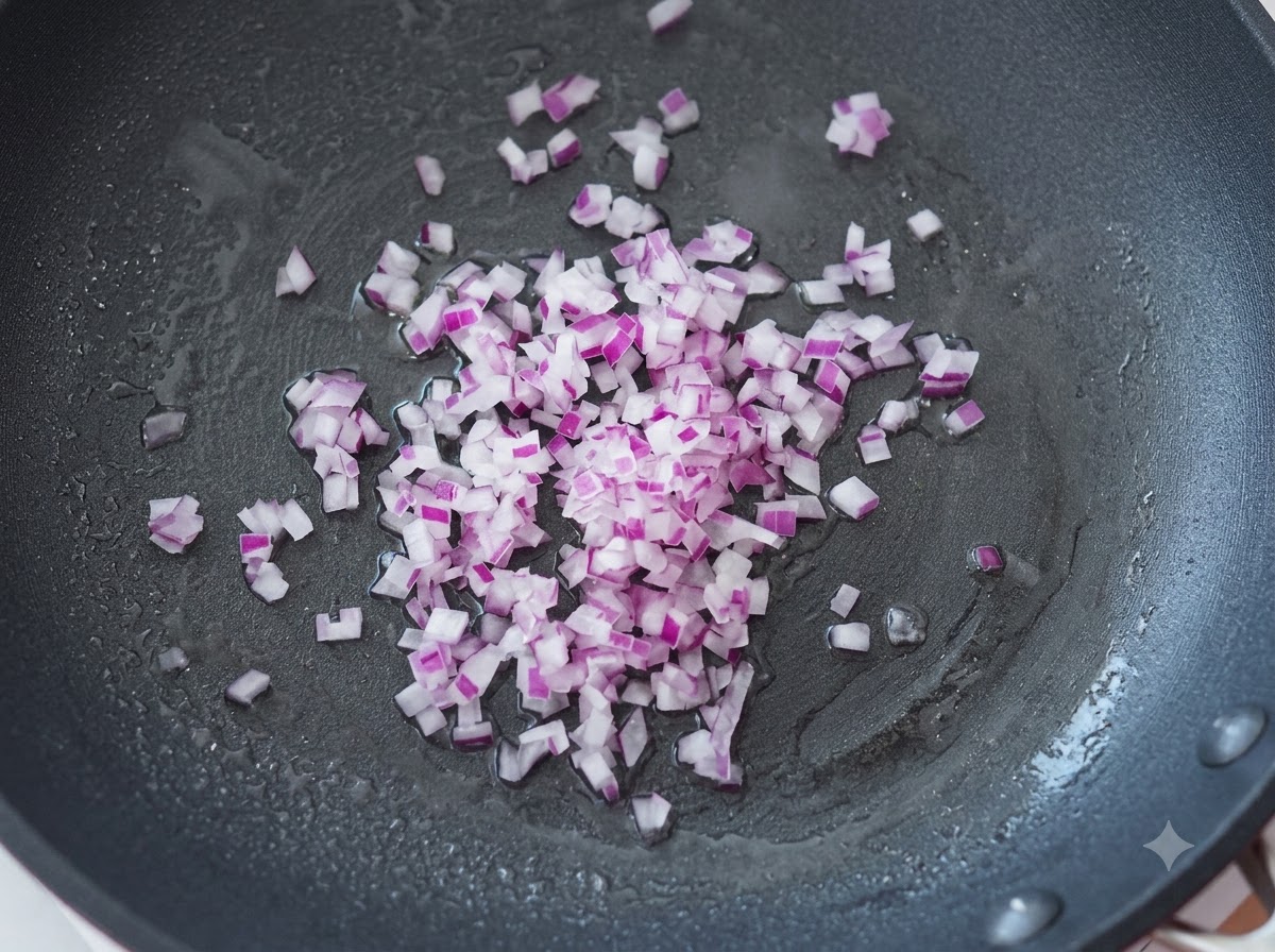 Fein gewürfelte lila Zwiebeln werden in einer heißen Pfanne mit Öl angebraten.