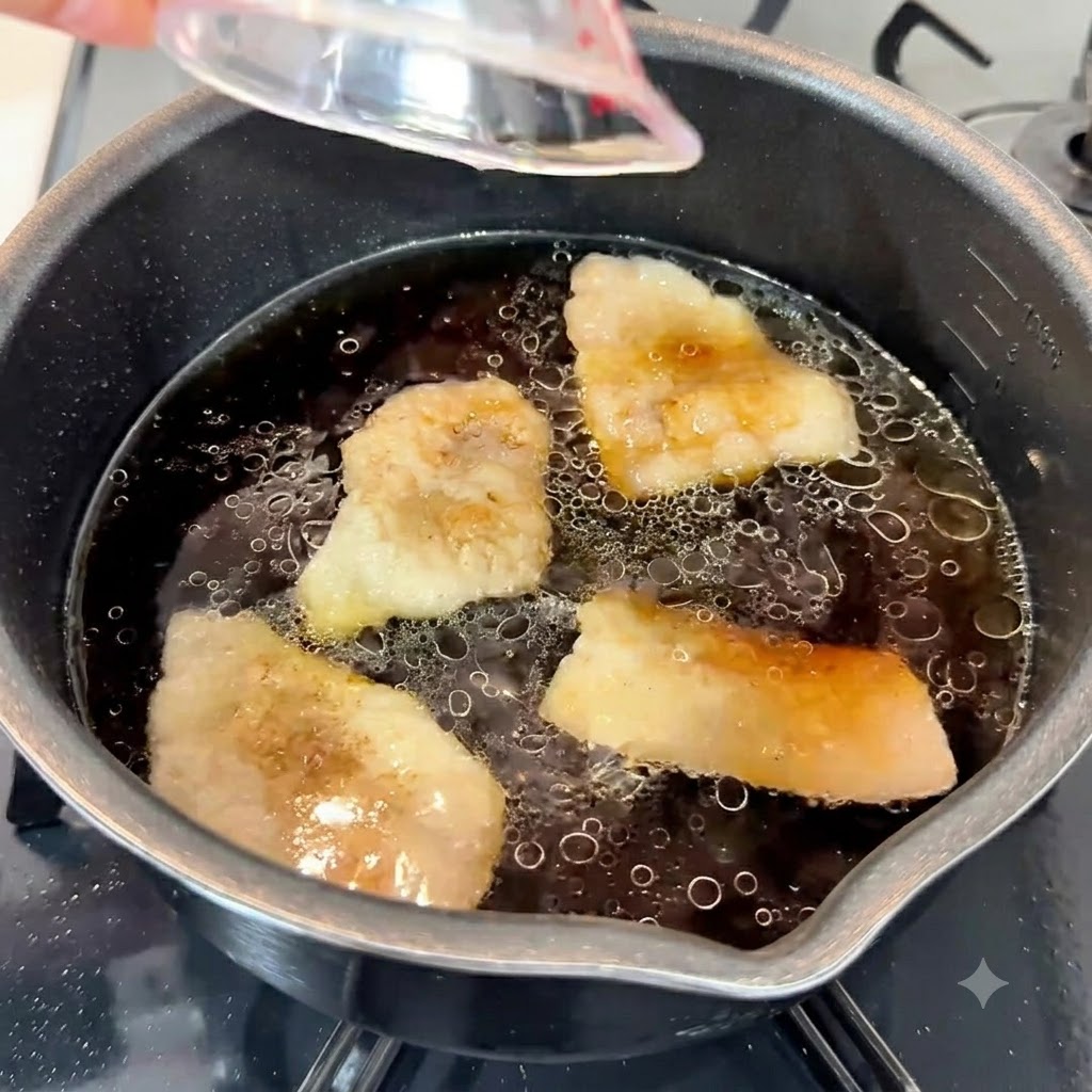 Knoblauchpaste, Sesamöl und weißer Zucker werden in die dunkle, aromatische Suppenbasis in einem Topf gegeben.