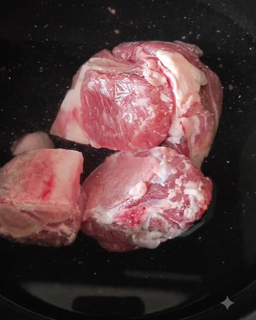 Rohe Schweinebeinknochen in einem Topf mit kochendem Wasser.