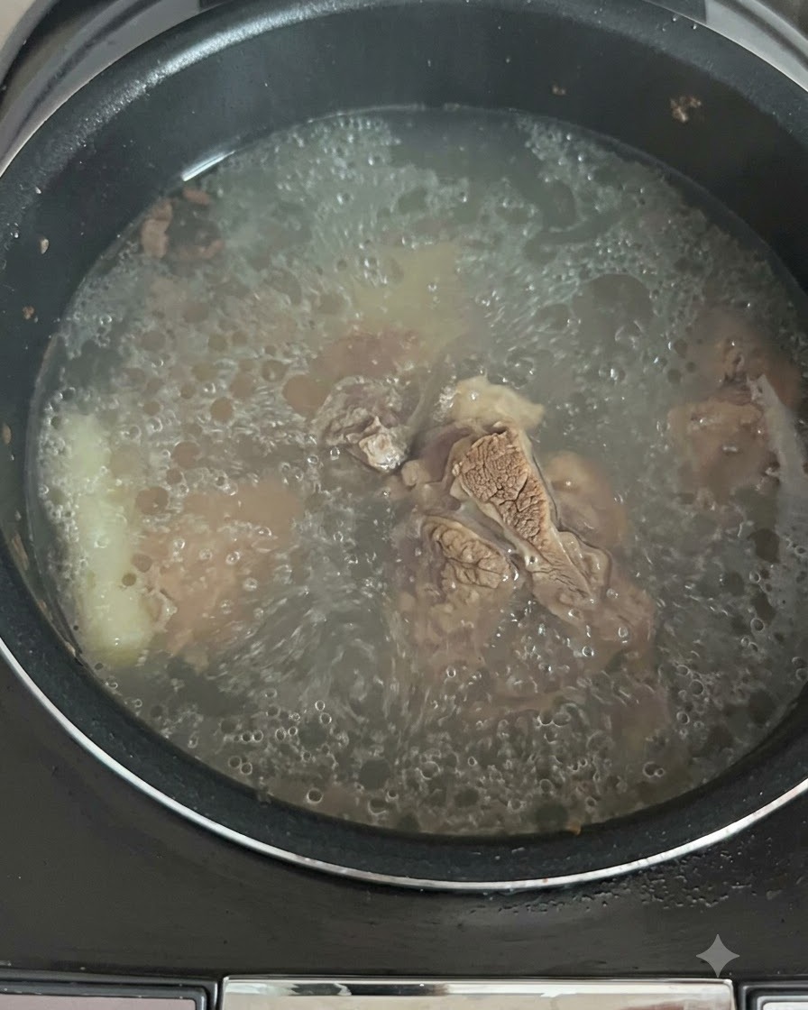 Die Brühe blubbert und kocht aktiv im Reiskochertopf.