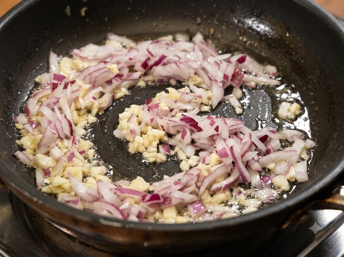 Gewürfelte rote Zwiebeln und gehackter Knoblauch brutzeln in heißen Öl in einer Pfanne.