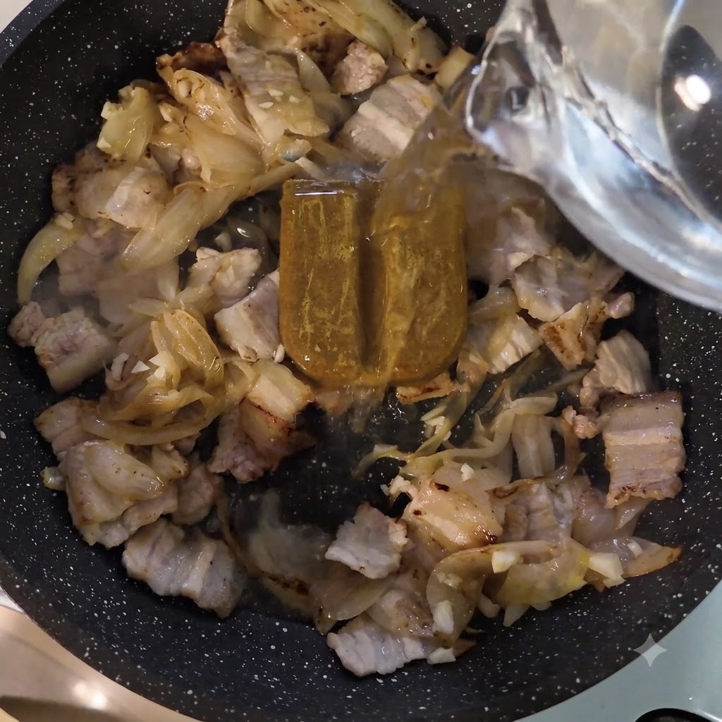 Wasser wird aus einem Gefäß über die Currypaste und das Fleisch in die Bratpfanne gegossen.