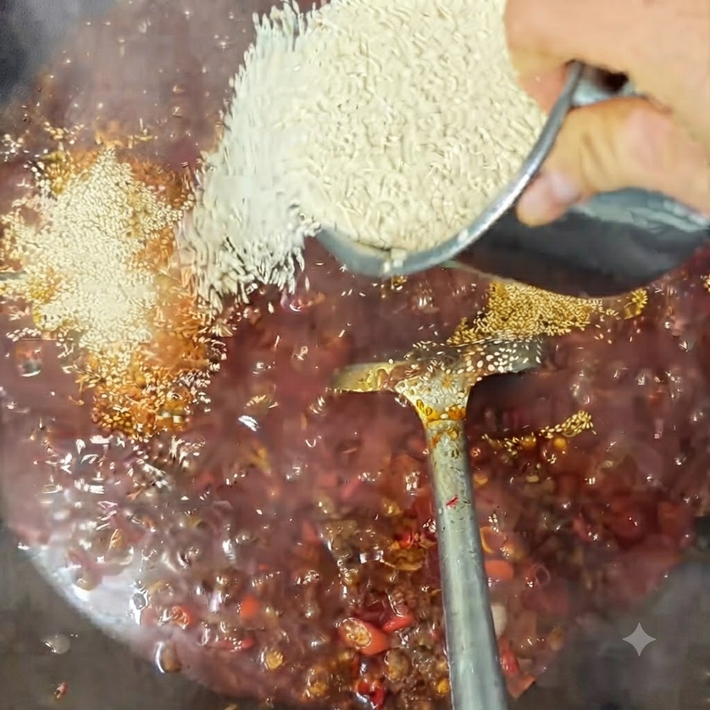 Weißer Sesam wird über die blubbernde Saucenmischung in einem Wok gestreut.
