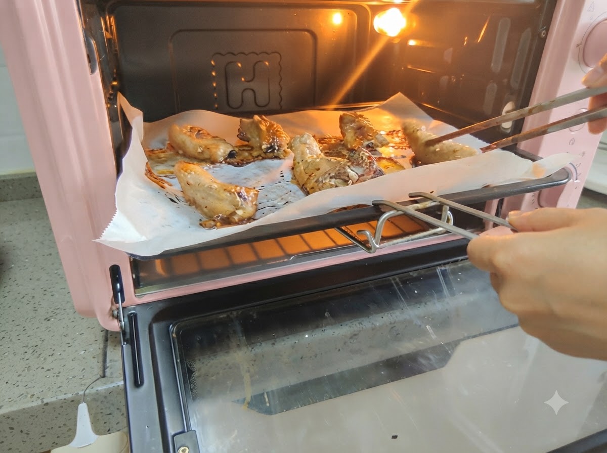 Schweinerippchen werden im heißen Ofen mit Hilfe von Stäbchen gewendet.