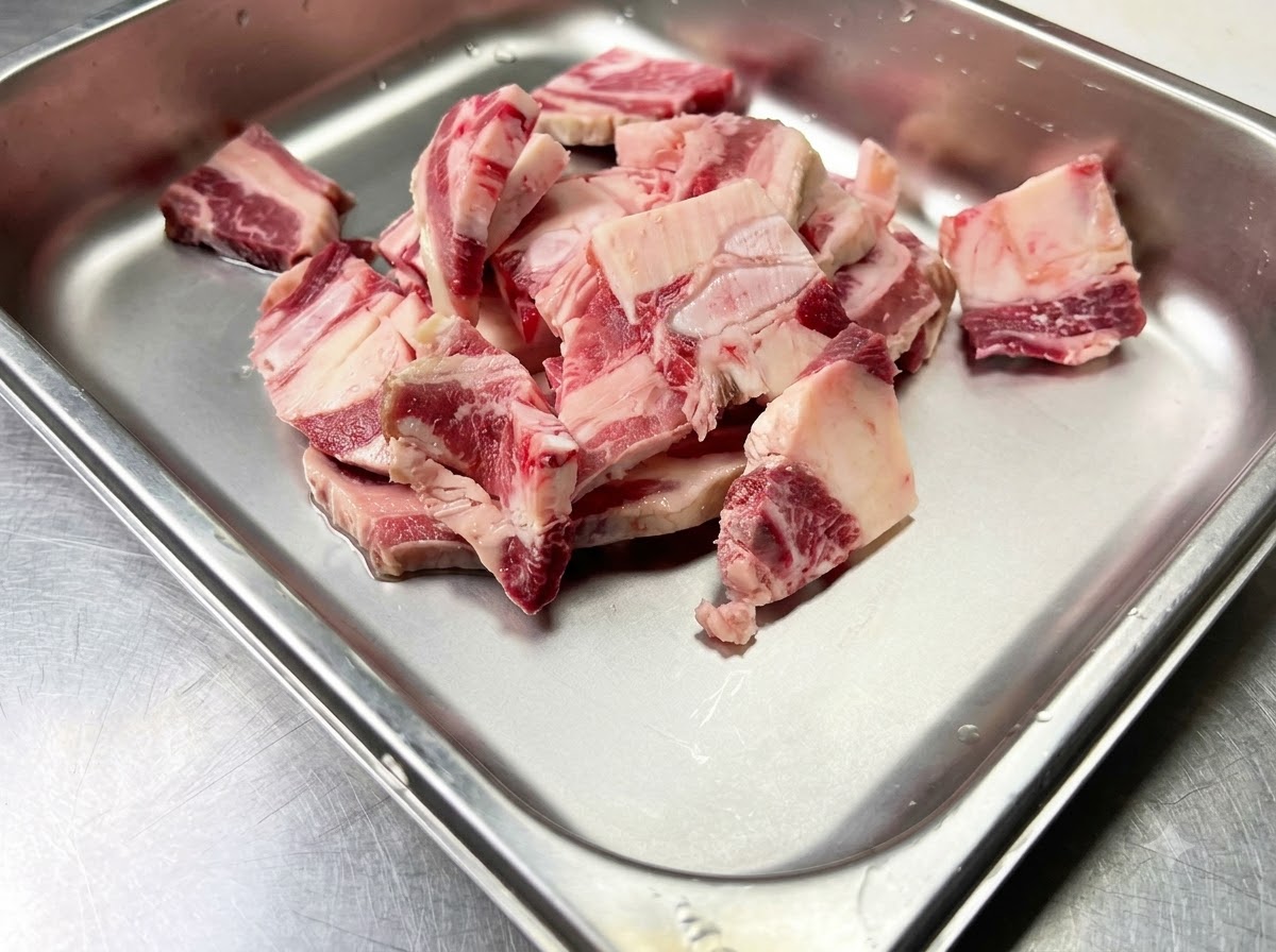 Rohe Rinder-Short-Ribs in einem sauberen Metallbehälter, bereit zum Würzen.