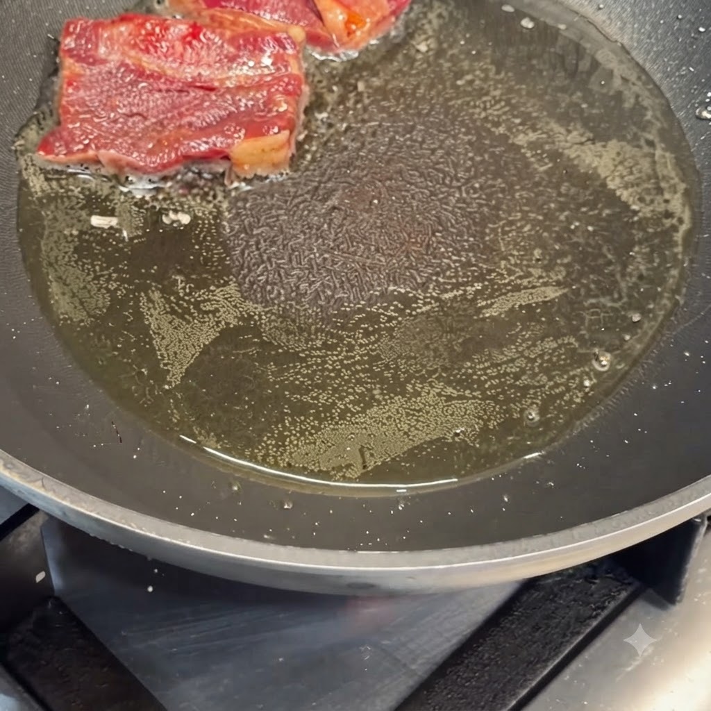 Marinierte Rinderrippchen braten in heißem Öl in einer Pfanne an.