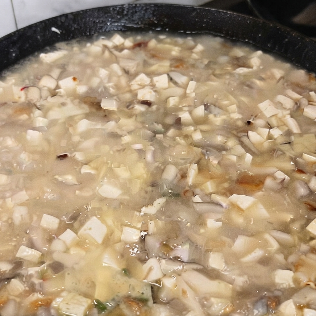 Eine Schaufel MSG wird zu der kochenden Tofusuppe gegeben.
