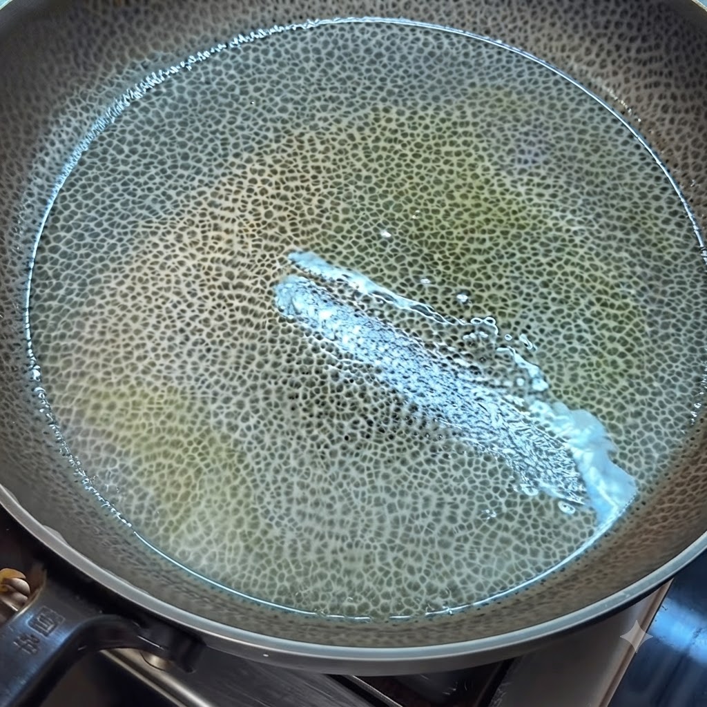 Verquirlte Eierflüssigkeit gart in einer eingefetteten Pfanne und wird mit einem Spatel in Stücke gerührt.