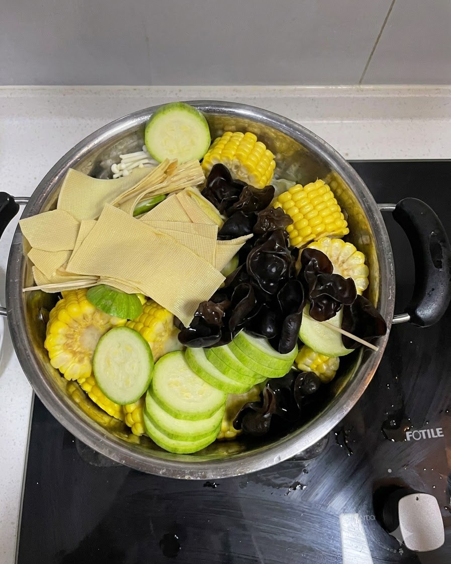Im Topf aufgeschichtetes Gemüse mit einer Portion Kimchi obenauf.