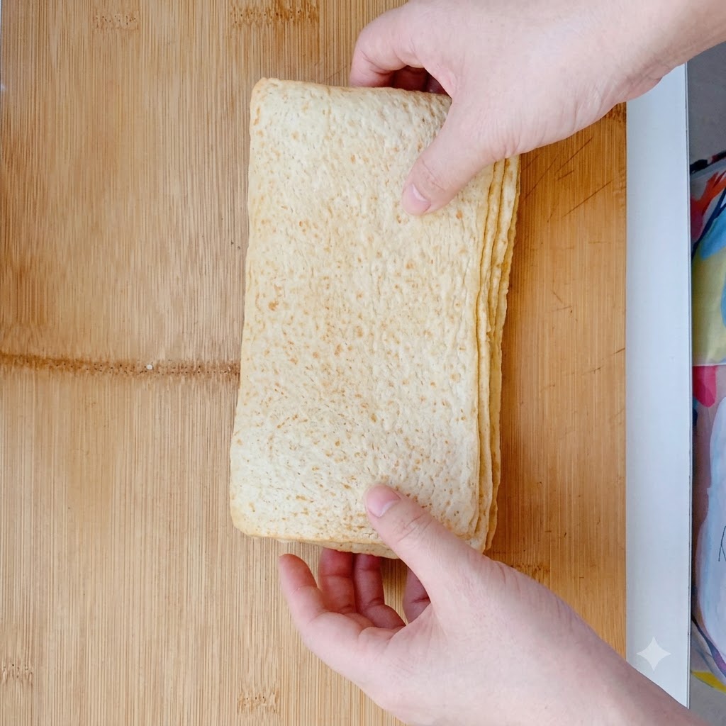 In große rechteckige Formen geschnittene Fischkuchen auf einem Holzschneidebrett.