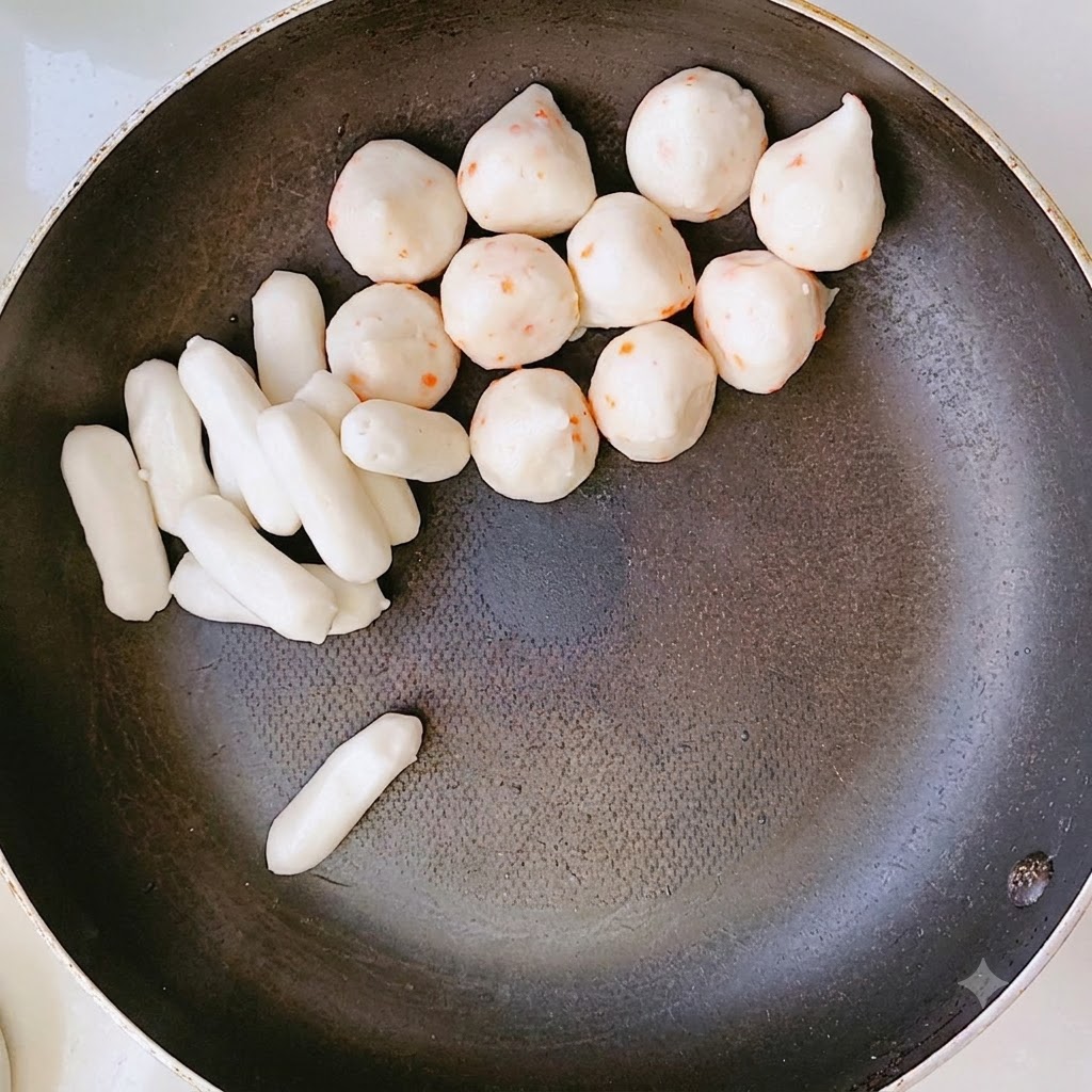 Eine Pfanne gefüllt mit angeordneten Schichten aus Reiskuchen und anderen Zutaten