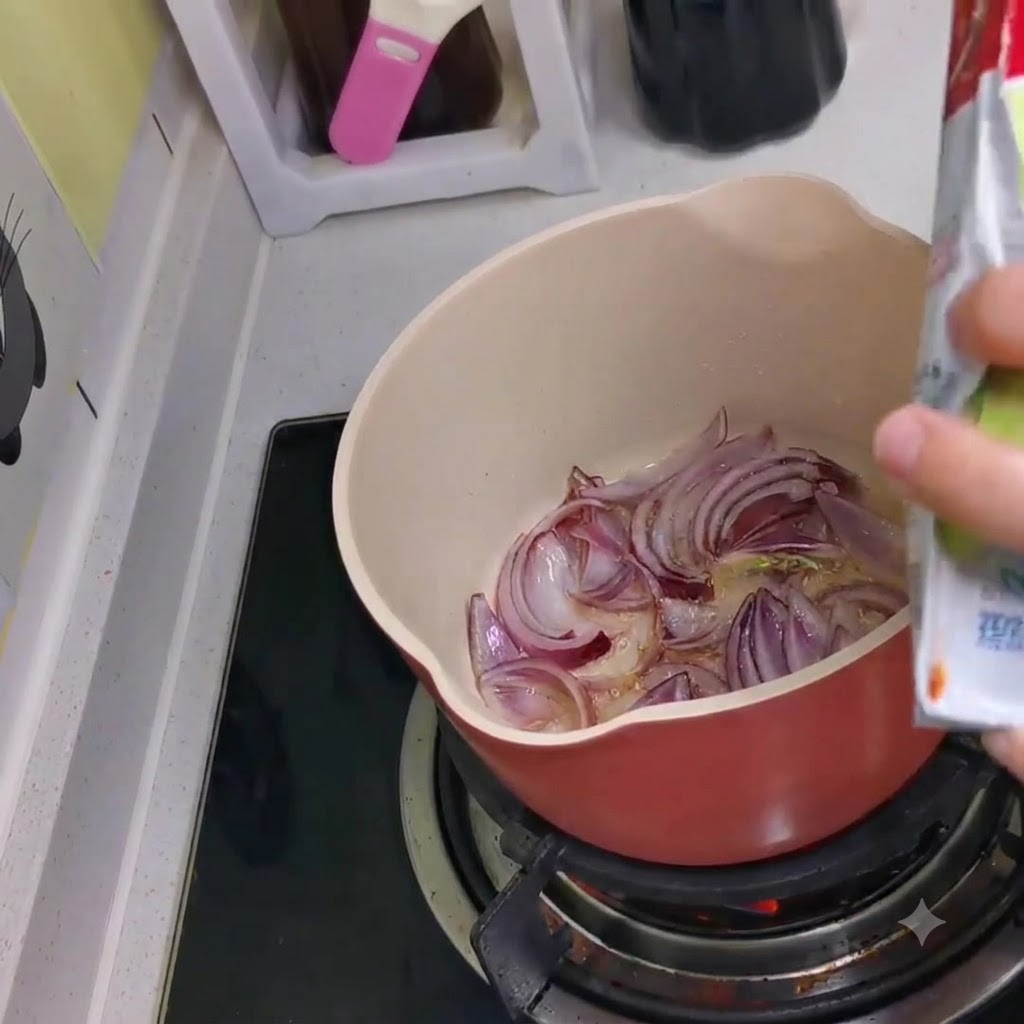 Kimchi wird aus einer Packung in den Topf mit den angebratenen roten Zwiebeln gefüllt.