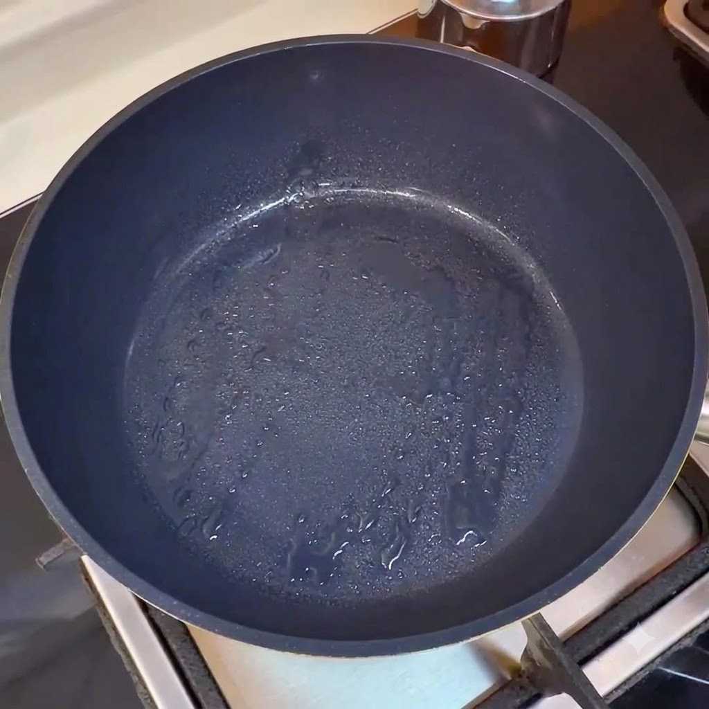Eine leere, erhitzte Pfanne macht sich bereit zum Kochen oder zeigt die Anfangsphase der Öl-Erhitzung.