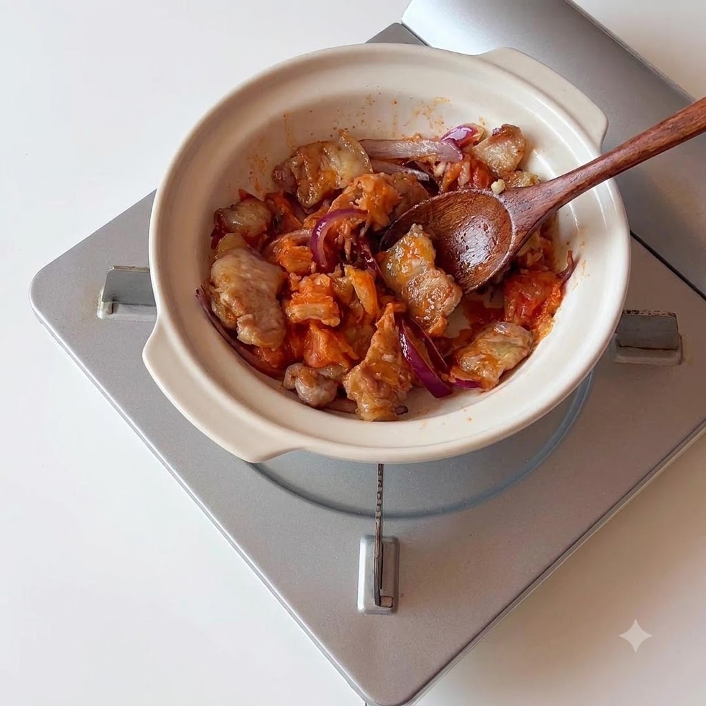 Wasser wird über die Schweinebauch-Kimchi-Mischung gegossen.