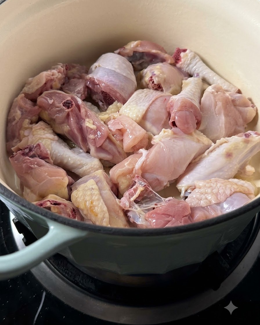 Hähnchenstücke braten im Topf an und beginnen Farbe anzunehmen.