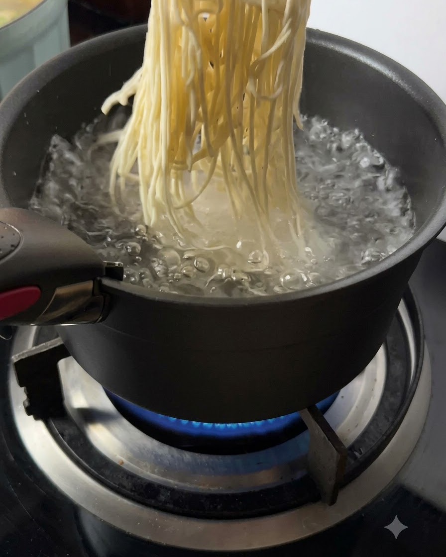 Frisch gemachte Nudeln werden in kochendes Wasser gegeben.