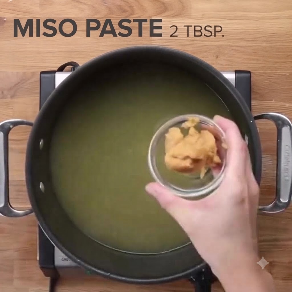 Misopaste wird in einen großen Topf mit Hühnerbrühe gegeben.